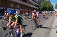 Varios ciclistas en plena carrera pasando por una calle de una ciudad.