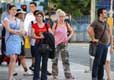 Un grupo de personas esperando, probablemente, a un medio de transporte público.