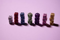 Un grupo de dados de distintos colores puestos en grupos según su color, los dados del mismo color están unos encima de otros, y los distintos grupos de dados puestos en fila unos al lado de otros. La mayor altura es de 3 dados y hay 7 grupos distintos.