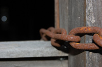Fotografía de unas cadenas de hierro oxidadas.