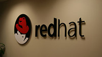 Imagen con el lLogotipo de Red Hat sobre una pared blanca.