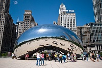 Ilustración de una escultura pública del artista indo-británico Anish Kapoor, es la pieza central de la Plaza AT&T en el Millennium Park en Chicago, Illinois, Estados Unidos. Fue construida entre 2004 y 2006. Compuesto por 168 placas de acero inoxidable soldados entre sí, en su exterior está pulido por lo que no tiene costuras visibles. Esta escultura tiene la apariencia de una haba gigante con una superficie de espejo y con su parte convexa apuntando al cielo. La escultura está en un parque delante de unos edificios de bastante altura.