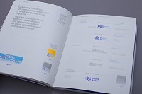 Ilustración con una guía de identidad visual abierta en la que se pueden apreciar diferentes conbinaciones de elementos y colores