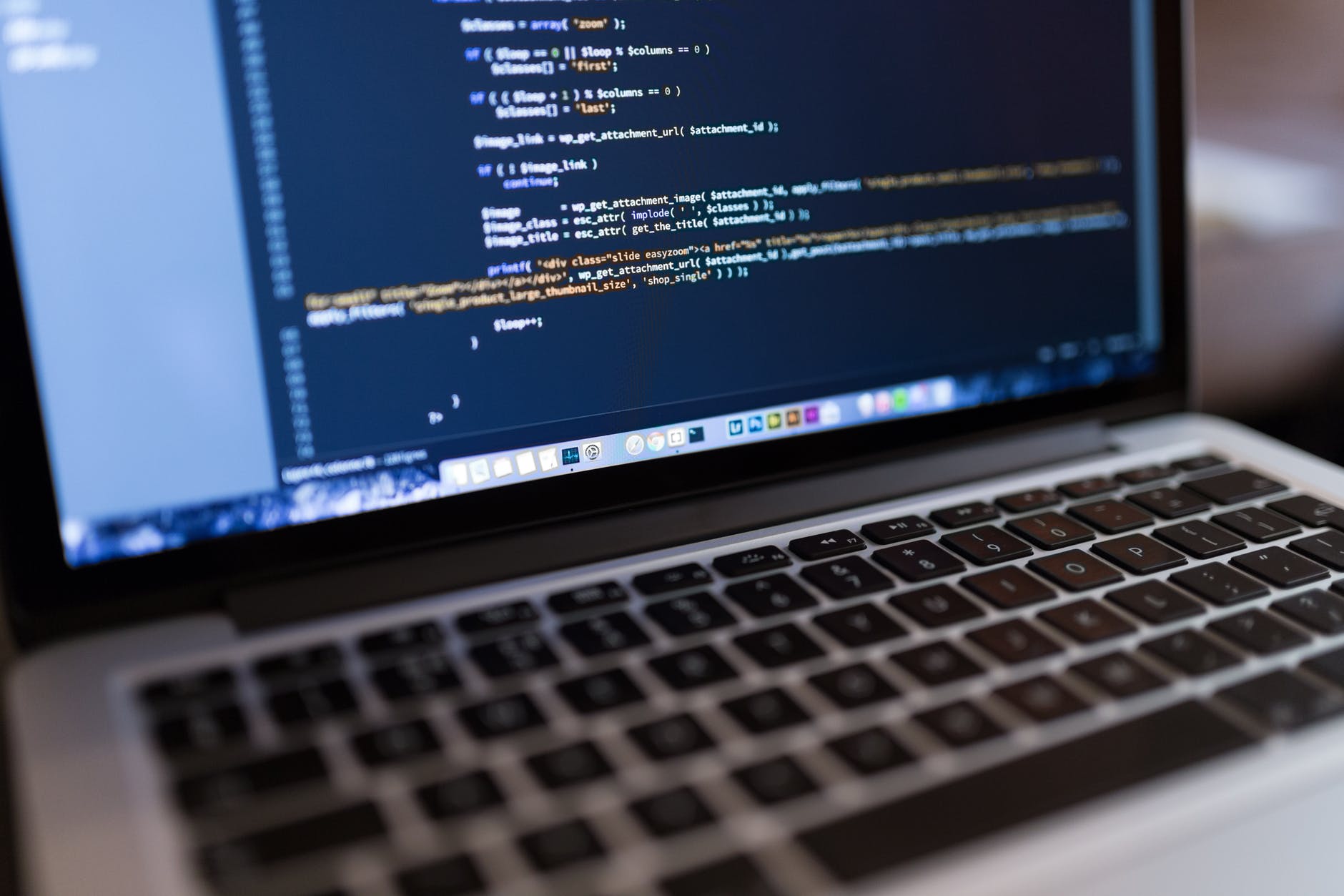 Creando objetos. Imagen de un ordenador portatil abierto, en la pantalla difuminado se pueder ver código escrito