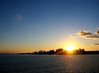 Puesta de sol en el mar mirando hacia tierra. 