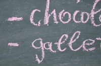 Lista de palabras escrita en una pizarra: chocolate y galletas.