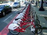 Puesto con bicicletas, de color rojo e identificadas con el logotipo de la empresa para alquilar.