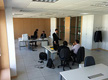 Foto de Lucía en uno de los lugares de trabajo de la gestoría, hablando con un compañero.