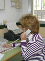 Imagen en la que aparece Rosa, la asesora fiscal, en su oficina. Aparece sentada delante de unas mesa, con un jersey a rayas, telefoneando a Jaime, para solicitarle las facturas necesarias para realizar la oportuna declaración de IVA