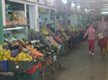 En esta imagen puedes observar el interior de un mercado de abastos. Puedes ver uno de los pasillos del edificio, donde se colocan, alineados en los laterales, los diferentes puestos de alimentos.  