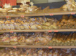 Imagen de un mostrador de pan de un horno, en la que puedes observar las filas de barras de pan y otros productos de panadería, esperando a ser consumidos por los clientes. 
