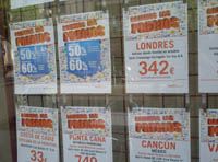 Imagen en la que puedes ver un escaparate de una agencia de viajes, que muestra, en un tablón, ofertas de distintos destinos turísticos.