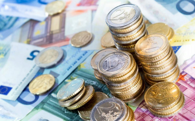 Imagen en la que aparecen billetes de distinto importe en orden, sobre un fondo negro.