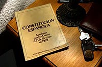 Ejemplar de la Constitución Española sobre una mesilla.