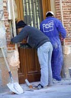 Trabajadores de la construcción obrando en una fachada.