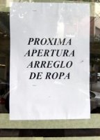 Fotografía del cartel anunciador de una tienda de próxima apertura dedicada al arreglo de ropa.