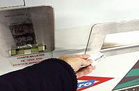 Una mano introduciendo un billete de metro en la máquina para ticarlo.