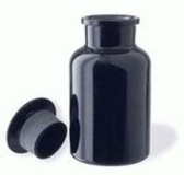 Bote de porcelana color negro con su tapón redondo junto a él.    