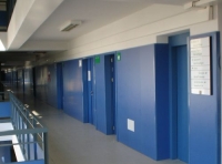 Departamentos. En la foto se aprecia un pasillo de la empresa donde están las puertas de los distintos departamentos. Pasillo y puertas están pintados de color azul.