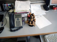 Se observa el teléfono y los sellos en un puesto de trabajo administrativo.