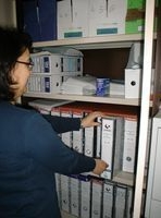 Archivo. Una administrativo busca una carpeta dentro de un armario. Foto realizada desde la parte posterior.