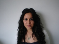 Alba. Se observa a una joven de pelo moreno, largo y rizado que mira sonriente a la cámara.