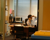 Hombre de negocios. Se muestra a un jefe tras su mesa de despacho hablando por teléfono y gesticulando con los brazos.