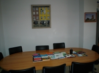 Mesa reunión. Se muestra una mesa de reunión, color marrón, rodeada de sillones y cuadro al fondo.