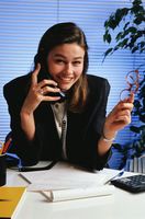 Mujer hablando por telefono con papel para tomar nota.