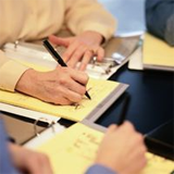 Varias personas trabajando con cuadernos de notas.