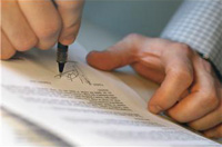 Una hoja de papel con texto manuscrito y una persona firmando con una pluma.