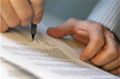 Una hoja de papel con texto manuscrito y una persona firmando con una pluma.