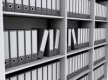 Estanterias grises con cajas archivadoras.