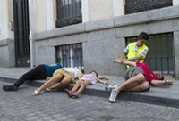 Juan atendiendo a un herido atropellado. Hay otras tres personas en el suelo, una de ellas una niña.