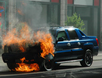 Fotografía un coche incendiado en una calle.