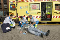 Fotografía de una ambulancia atendiendo a un hombre inconsciente en la calle.