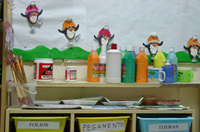 Fotografía de un aula de infantil con unas estanterías. Diversos botes y botellas de productos químicos se encuentran encima de la estantería.