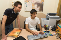 Ángel, con uno de sus compañeros de la residencia, durante su estancia en la misma visualizando el expediente individual de una de las personas usuarias.