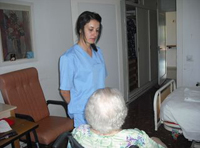 Imagen de una trabajadora de una residencia de ancianos en actitud fría y distante ante una anciana en silla de ruedas.