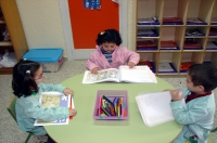 Fotografía de unos niños leyendo en una escuela de educación infantil