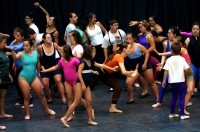 Fotografía de un grupo de bailarines y bailarinas con discapacidad, integrantes del Psico Ballet de Maite León ensayando en un escenario.