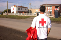 Fotografía de un voluntario de Cruz Roja, de espaldas, caminando hacia un edificio de la organización.