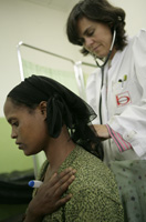 Fotografía de una consulta de un hospital donde una médica ausculta a una paciente para comprobar su estado de salud.