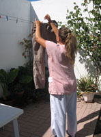 Esther. Una chica de 22 años. Es rubia con el pelo  recogido hacia atrás. Tiene dos perlas grandes blancas como pendientes y viste un uniforme a rayas rosas y blancas. Tiende ropa en el patio.