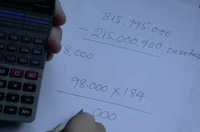 Una persona realiza cálculos en un papel utilizando para ello una calculadora.