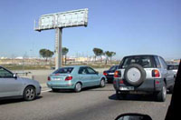 Varios coches circulando por una autovía en caravana.