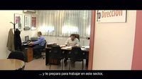 Se ve en un despacho en cuya puerta pone dirección, cómo trabajan dos personas.