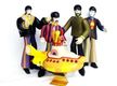 Muñecos caracterizados de los Beatles.