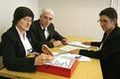 Tres personas están leyendo unos documentos.