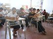 Alumnos y alumnas haciendo un examen.
